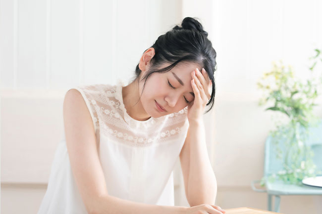頭が痛い様子の女性