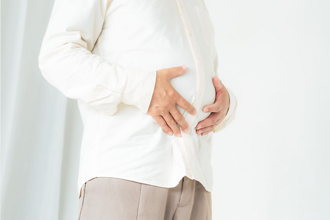お腹をおさえる男性